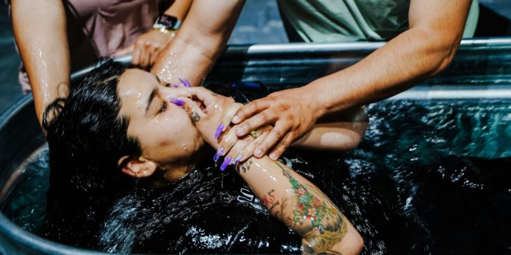 a man sitting at a table with his hand on his face